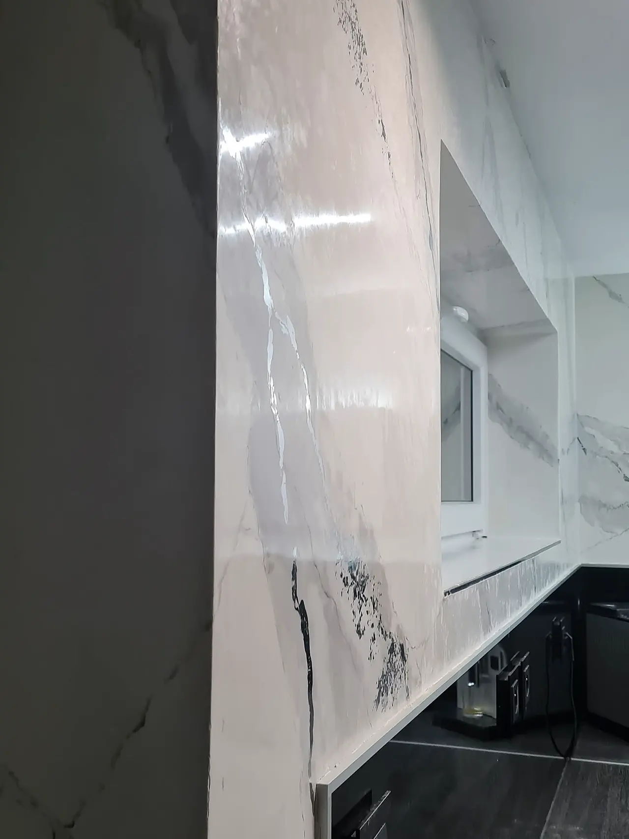 Lesklá mramorová kresba přecházející bez spáry přes ostění okna
